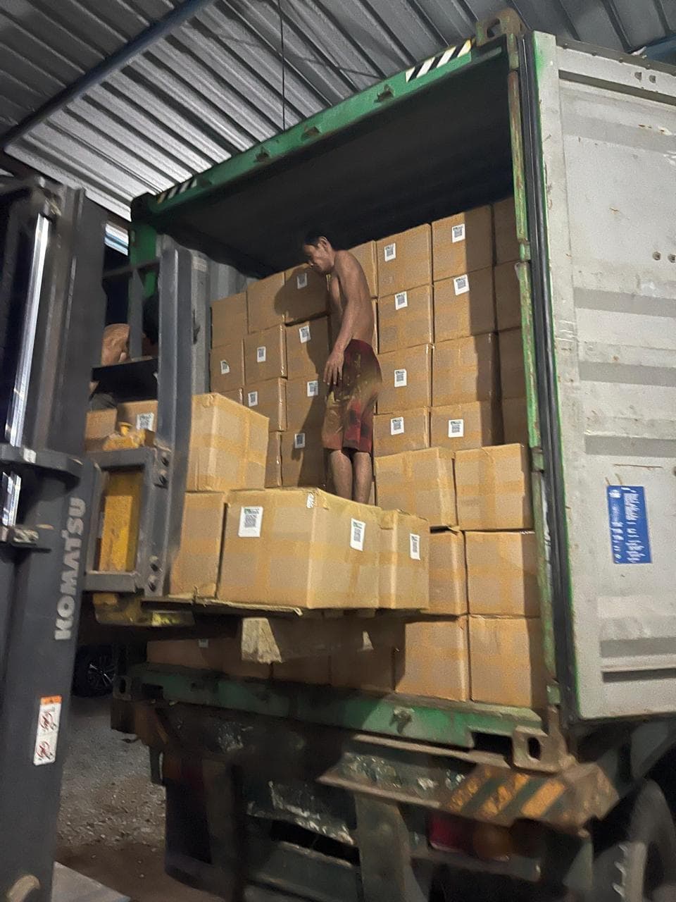 Forklift loading cartons into ocean freight container